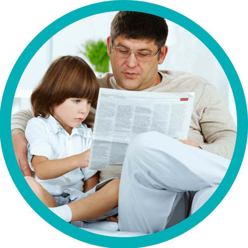 A boy reading newspaper with his father