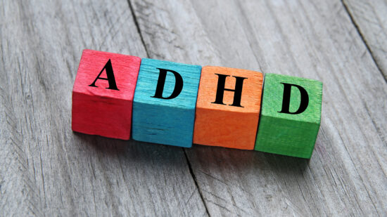 colours blocks on a wood floor spelling ADHD