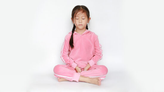 photo of a young girl sitting on a floor meditating